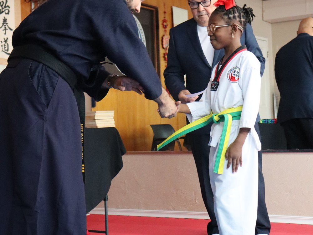 A student receiving their new belt